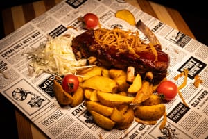 Coaste de porc cu sos BBQ, ceapă crocantă, salată de varză și cartofi wedges